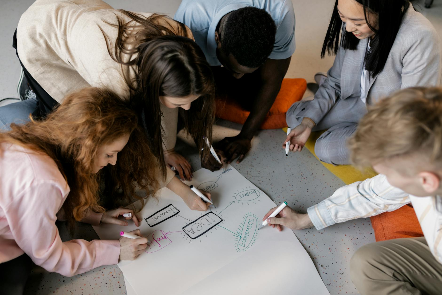 group of young people developing a business idea on paper